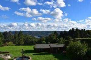 a barn in a field with a view of a lake at Hotel Haus Seeblick in Nideggen