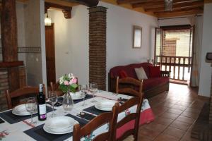 a dining room with a table with a bottle of wine at Apartamentos Rurales Rosendo: La Madre Selva in Capileira
