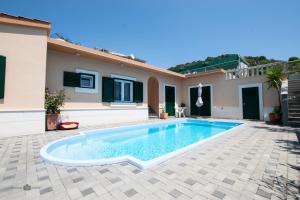 a villa with a swimming pool in front of a house at Summer rental house "Kava" in Okrug Donji +30 photos