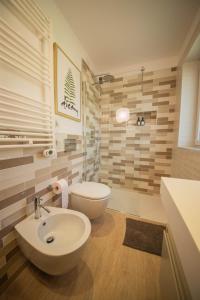 La salle de bains est pourvue d'un lavabo blanc et de toilettes. dans l'établissement Gardenhouse Sarzana, à Sarzana
