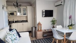 a living room with a white couch and a table at Innes Road Durban Accommodation 2 bedroom private unit in Durban
