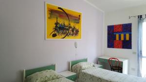 Un dormitorio con dos camas y un cuadro en la pared. en Casa Giusy, en Capo Vaticano