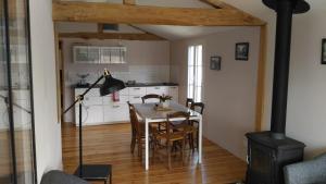 a kitchen and dining room with a table and a stove at Le Gué Renard-un Balcon Sur La Charente in Jarnac