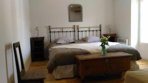 una camera da letto con un letto e un vaso di fiori su un tavolo di Le Gué Renard-un Balcon Sur La Charente a Jarnac