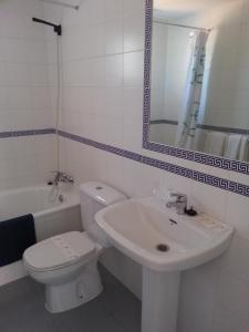 a bathroom with a sink and a toilet and a mirror at Hotel San Miguel in El Rompido