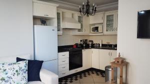 a kitchen with white cabinets and a white refrigerator at Innes Road Durban Accommodation 2 bedroom private unit in Durban