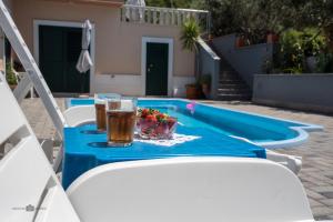 a table with a drink and a bowl of fruit next to a pool at Summer rental house "Kava" in Okrug Donji