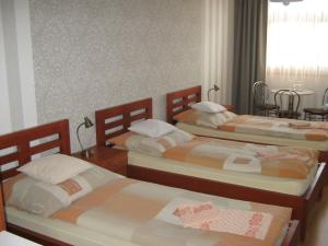 a bedroom with two beds and a table at Penzion U Radnice in Kyjov