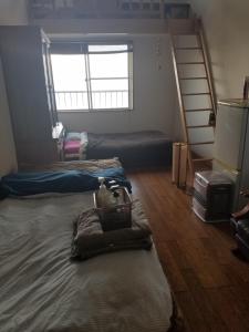 a bedroom with two beds and a bunk bed at Ocean Home Guest House in Miyazaki