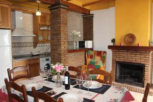 ein Esszimmer mit einem Tisch und einem Kamin in der Unterkunft Apartamentos Rurales Rosendo: El Azahar in Capileira