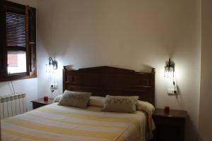 ein Schlafzimmer mit einem Bett mit zwei Kissen darauf in der Unterkunft Apartamentos Rurales Rosendo: El Azahar in Capileira