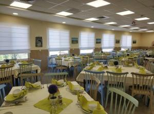 a dining room with tables and chairs with yellow napkins at Aloney Habashan Guest village in Alonei Habashan +41 photos