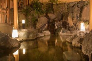 a room with a pool of water with two lights at Ito Kowakien in Ito