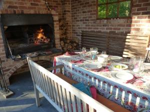 a table with plates on it in front of a fireplace at Traumhaftes Luxus-Ferienhaus in Warnkenhagen