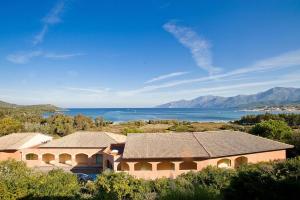 a building with a view of the water and mountains at Studio A Suarella in Saint-Florent