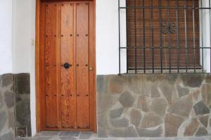 uma porta de madeira na lateral de um edifício em Apartamentos Rurales Rosendo: El Romero em Capileira