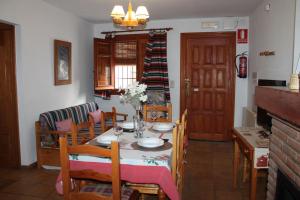 a dining room with a table and some chairs at Apartamentos Rurales Rosendo: El Romero in Capileira
