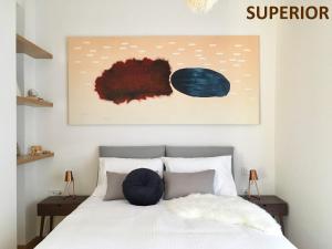 um quarto com uma cama com um quadro por cima em Sunkissed Rooftop Apartments em Atenas