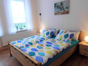 Schlafzimmer mit einem Bett mit einer blauen und weißen Bettdecke in der Unterkunft Ferienhaus Alte Tante in Thale