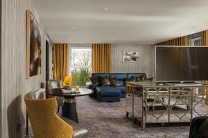 a living room with a couch and a tv at Hetland Hall Hotel in Dumfries