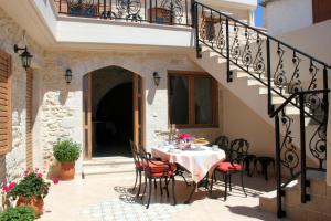 a table and chairs on a patio with a staircase at Ioanna House in Gonia