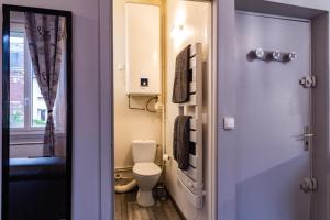 a small bathroom with a toilet and a window at Cosy'Appart - COEUR DE SEINE in Rouen +16 photos