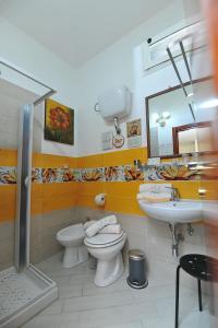 bagno con 2 servizi igienici, lavandino e specchio di B&b Le Cycas a Castellammare di Stabia
