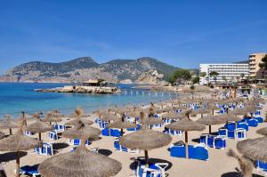 a bunch of umbrellas and chairs on a beach at Country House With A Pool In Port D'Andratx in Andratx