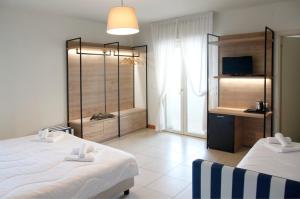 a hotel room with two beds and a television at Hotel Majorca sul Mare in centro a Riccione in Riccione