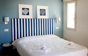 1 dormitorio con 1 cama blanca grande y 2 toallas en Hotel Majorca sul Mare in centro a Riccione, en Riccione