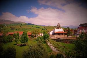 un piccolo villaggio con una chiesa in un campo verde di Habitaciones Casona De Linares a Selaya
