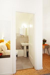 een badkamer met een wastafel, een toilet en een bed bij Le Quinte del Bellini in Napels