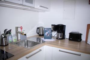 a kitchen counter with a sink and a coffee maker at Welcome in - Wohnung mit Dachterrasse direkt an der Piste in Winterberg