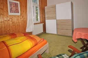 a bedroom with a bed and a table in it at Ferienwohnungen im Harz in Altenbrak