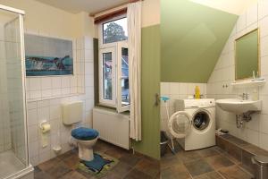 a bathroom with a sink and a washing machine at Ferienwohnungen im Harz in Altenbrak
