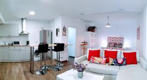 a living room with a white couch and a kitchen at Loft Azahar junto a Puente Romano in Córdoba