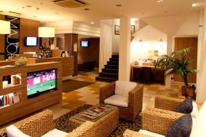 a living room with a tv and a couch and chairs at Hotel Majorca sul Mare in centro a Riccione in Riccione