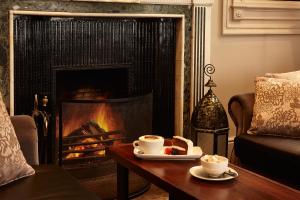 a living room with a coffee table and a fireplace at Hetland Hall Hotel in Dumfries