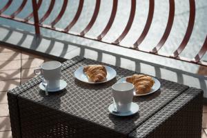 two plates of croissants and cups on a table at Harmony in Amalfi