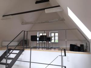een zolderkamer met een glazen trap en 2 bureaus bij Apartment Rampendal im Lemgoer Fachwerkhäuschen in Lemgo