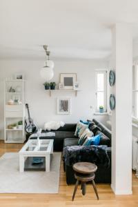 a living room with a black couch and a table at Hallstatt Lake View House in Hallstatt