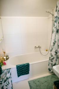 a white bathroom with a tub and a sink at Hallstatt Lake View House in Hallstatt +34 photos
