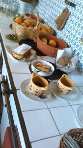 una mesa con platos de comida y una cesta de fruta en La Zizzania e il Mandarino, en Roccagloriosa