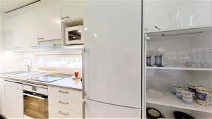 a white kitchen with a refrigerator and a sink at Pirjola in Seinäjoki