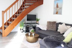 a living room with a couch and a tv at Appartement Bilbao in Sankt Peter-Ording