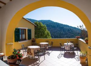 a patio with tables and chairs on a balcony at Agriturismo A Cà Vegia in Calice Ligure