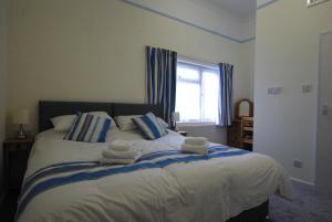 a bedroom with a large bed with towels on it at The Sandhill in Sandown