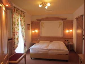 een slaapkamer met een bed in een kamer bij Park Hotel Aurora in Pozza di Fassa