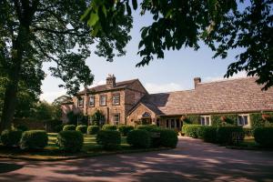 uma grande casa de tijolos com uma entrada em The Devonshire Arms Hotel & Spa - Skipton em Bolton Abbey