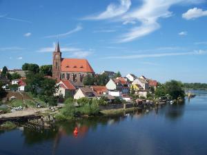 a town with a church and a body of water at Fewo Am Marktplatz I in Eisenhüttenstadt